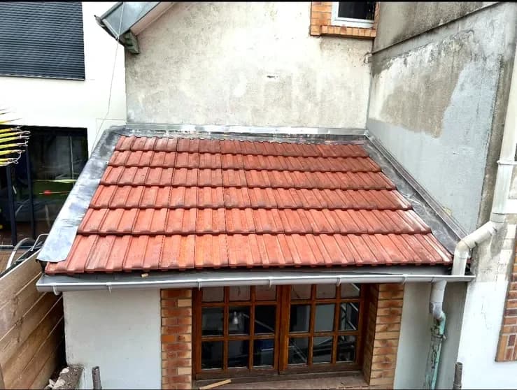 Un appentis couvert en tuiles avec sa gouttière et sa zinguerie neuves