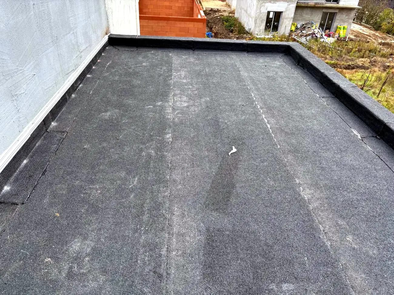 Une toiture terrasse recouverte d’une membrane bitumineuse neuve, surface uniforme